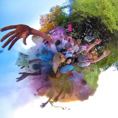 a group of people standing in front of a tree with their hands on the ground