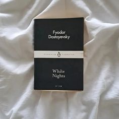 two black and white books laying on top of a white bed sheet with the words fyodor dostopevlevky