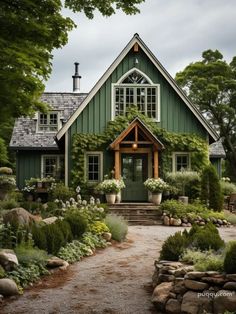 a green house with lots of windows and plants on the front door is surrounded by greenery