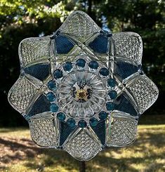 an ornate glass sculpture in the shape of a flower on top of a wooden stand