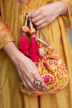 "Our Alanna potli is detailed with thread and zari and sequin embroidery on soft silk. Pair this with a vibrant pink ensemble and watch it stand out as a statement accessory! Colour: Mustard with pink Embroidered front and back. Dimensions (LxB): 8.5\"×9.5\" Handle drop: 5\" Material : Embroidered silk, gold tissue, poly satin lining, woven gold thread drawstrings and silk thread tassle detailing." Handwork Embroidered Fabric For Festivals, Festive Handwork Embroidered Fabric For Diwali, Multicolor Potli Bag For Wedding And Navratri, Festival Multicolor Embroidery Potli Bag With Zari Work, Festive Multicolor Embroidery Potli Bag, Festive Multicolor Embroidered Handwork Potli Bag, Festive Multicolor Embroidered Potli Bag With Handwork, Festive Multicolor Embroidered Potli Bag, Multicolor Embroidery Zari Work Potli Bag For Festivals