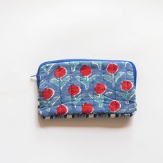 a blue and red flowered wallet sitting on top of a white table