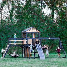 children playing on a wooden play set in the grass