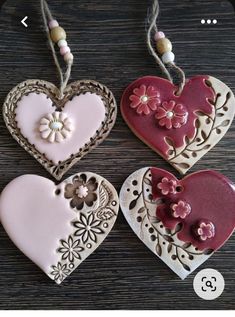 three heart shaped cookies hanging from strings on a table