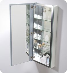 the medicine cabinet is open and has many items in it's glass doors on both sides