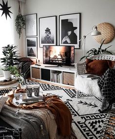 a living room filled with lots of furniture and pictures on the wall next to a window