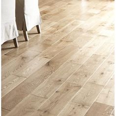 a wooden floor with white table cloths and chairs in the background on a hardwood floor