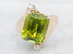 "Filling the finger without being overly weighty or ostentatious, this vintage ring features the best lines of modern style design. We've chosen a lime green peridot with two sparkling diamonds to anchor the visual aspects of this gorgeous vintage ring! Metal: 14K Yellow Gold Gem: Peridot 4.62 Carats Gem Measurements: 10.9 x 8.8 mm, Emerald Cut Accents: 2 Diamonds totaling .07 Carats, SI in Clarity, H in Color Ring Size: 6.25 Marks: \"14K\" Stamped on the inside band To view a video of this piec Peridot Ring Gold, Gold Peridot Ring, Channel Set Diamond Band, Garnet Ring Vintage, Amethyst Cocktail Ring, Petite Earrings, Modern Style Design, Vintage Cocktail Ring, Peridot Jewelry