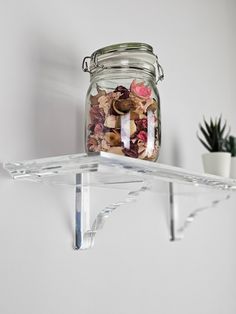 a glass jar filled with coins sitting on top of a shelf