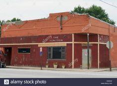 an old red brick building on the corner of a street with a truck parked in front