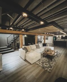 a living room filled with furniture and a fire place in the middle of a wooden floor