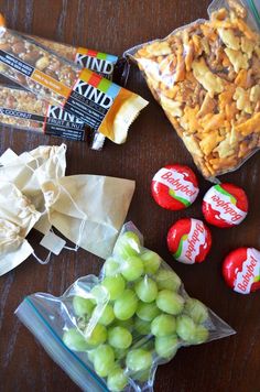 some snacks are sitting on a table next to candy and other items that include grapes