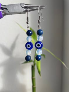 These beautiful, unique, and handmade earrings are made with evil eye charms, opalite beads, and blue accent beads.  evil eye- protects from negativity and harmful energy  opalite (third eye chakra) (zodiac signs: scorpio, libra)- improves communication, psychic abilities, removes energy blockages, assists during transition Blue Evil Eye Dangle Jewelry, Blue Evil Eye Dangle Earrings, Handmade Blue Spiritual Earrings, Blue Handmade Spiritual Earrings, Blue Spiritual Dangle Earrings, Spiritual Blue Dangle Earrings, Spiritual Evil Eye Dangle Jewelry, Nickel-free Spiritual Beaded Earrings, Blue Round Beads Spiritual Earrings