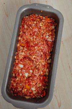 a casserole dish with meat and vegetables in it on a wooden table top