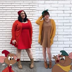 two women standing next to each other in front of a brick wall with cartoon characters