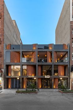 an empty parking lot in front of a tall brick building with several stories on it