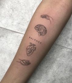 a person with a tattoo on their arm that says balance and two hands holding a heart