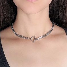 "A silver chunky curb chain choker necklace featuring a toggle clasp closure that can be worn front or back. Made from a stainless steel chain and clasp, this necklace wont fade and is completely hypoallergenic! Chain link measurements: 8mm x 5.5mm The length shown in photos is 15\" and I have more sizes available from the dropdown menu. If you have a custom request, feel free to message me! I ship out every weekday, Monday through Friday. This item ships securely in a 3.5\" x 3.5\" gift box. Ch Cheap Chunky Chain Choker, Cheap Metal Chunky Chain Choker, Punk Choker, Shell Heart, Gold Pearl Jewelry, 90s Goth, Goth Necklace, Essential Oil Necklace Diffuser, Amulet Necklace