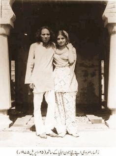 an old photo of two people standing in front of a building with arabic writing on it