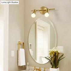 a bathroom sink with a mirror above it and lights on the wall next to it