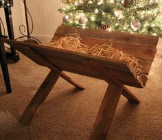 a christmas tree is in the corner of a room with a small wooden bench underneath it