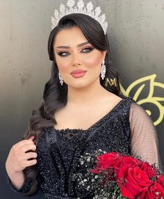 a woman wearing a tiara and holding flowers