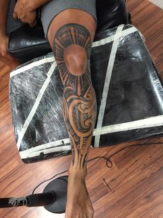 a person sitting on top of a chair with a tattoo on their leg and arm