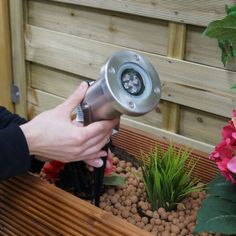 a person using a garden light in a planter