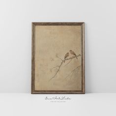 two birds sitting on top of a tree branch in front of a wall mounted painting