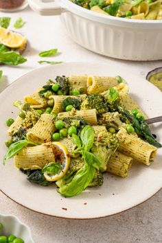 pasta with peas, broccoli and spinach in a white bowl on a table