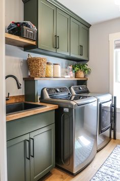 a washer and dryer sitting in a kitchen next to green cupboards on the wall