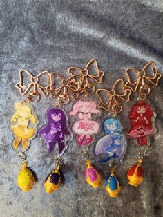 a bunch of key chains that are on top of a cloth covered surface with cartoon characters attached to them