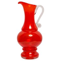 a red glass vase sitting on top of a table