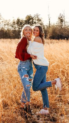 two women hugging in a field of tall grass