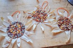 three paper bags filled with candy sitting on top of a wooden table