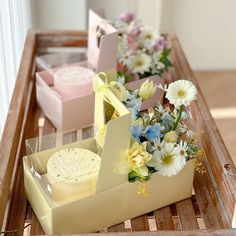 three small boxes with flowers in them sitting on a table