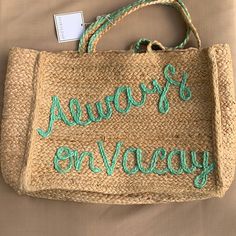 a straw bag with embroidered words on it