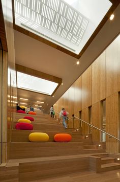 people are walking up and down the stairs in an office building with wood paneling