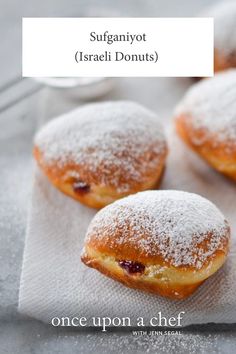 three pastries sitting on top of a white towel covered in powdered sugar and cranberry sauce