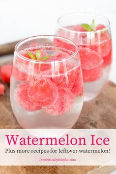 two glasses filled with watermelon ice sitting on top of a wooden cutting board