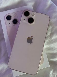 two new iphones are sitting next to each other on a white sheet with the box open