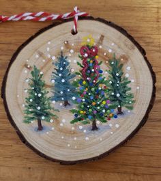 a wooden ornament with christmas trees painted on it