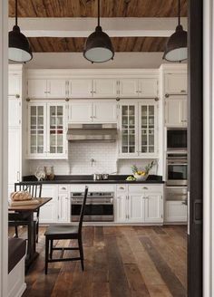 a kitchen with white cabinets and wood floors is featured on instagram for real estate