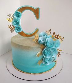 there is a cake with blue frosting and gold decorations on the top that says c