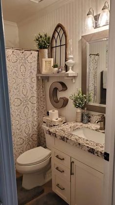 a bathroom with a toilet, sink and mirror in it's centerpieces