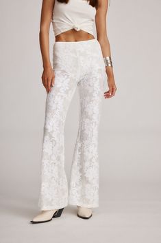 Swap out your denim for these one-of-a-kind pants, made from white lace with rhinestones scattered throughout. With sheer legs and a slight flare silhouette, the Maddox Pants pair well with crop tops, oversized graphic tees, and more. Prepare to shine bright, no matter where the day takes you. Lace Flare Pants For Party, Flare Lace Bottoms For Party, Lace Flare Bottoms For Party, White Stretch Bottoms For Festivals, White Bohemian Stretch Pants, White Full-length Bohemian Bottoms, White Stretch Bohemian Pants, White Bohemian Full Length Bottoms, Party Bottoms With Lace Trim Long Pants