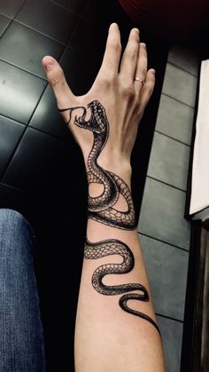 a person's arm with a tattoo on it that has a snake on it