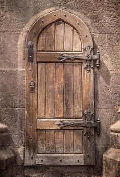 an old wooden door with wrought iron handles