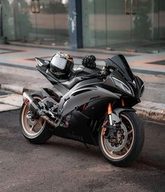 a black motorcycle parked on the street next to a curb with no people around it