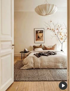 a bedroom with a large bed sitting next to a doorway and a painting on the wall